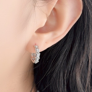 Silver snake-scale earrings with pavé trapezoid zirconias shown on a female model