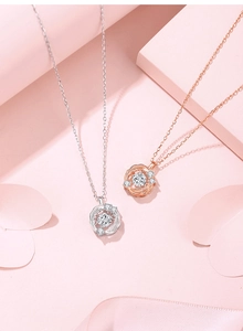 Detailed shot of silver and rose gold swirl pendants with sparkling gemstones on pink decor