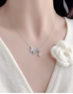 Close-up of S925 silver butterfly necklace with blue enamel and zircon on a model