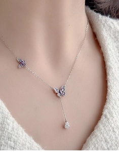 Close-up of 925 silver Y-shaped necklace with purple enamel butterflies and pear pendant