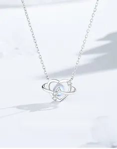 Macro view of S925 silver heart planet pendant with blue moonstone and fine diamonds