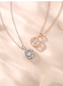Detailed view of S925 silver and rose gold dancing stone pendants on soft fabric