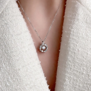 S925 sterling silver necklace with moving crystal pendant on tweed coat background