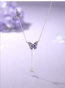 Detail of silver Y-shaped butterfly necklace with purple enamel and pear-cut zircon
