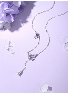 Detail of 925 silver necklace featuring purple enamel butterfly and pear-cut gemstone