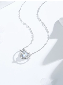 Macro detail of S925 silver heart planet pendant with moonstone and cubic zirconia
