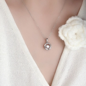 Elegant s925 silver dancing heart necklace on a model with white knitwear outfit