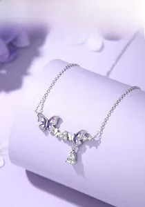 Detail of 925 silver necklace with purple enamel butterfly and drop zircon pendant