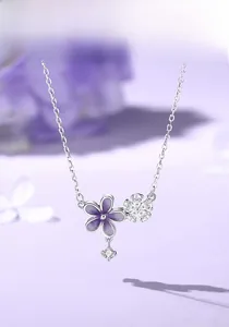 Macro detail of S925 silver necklace with purple enamel flower and sparkling zircon charms