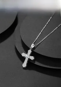 Detailed close-up of a silver cross pendant featuring sparkling cubic zirconia stones