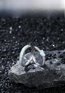 Détail de bagues de couple en argent S925 avec texture roche et émail coeur bleu sur pierre