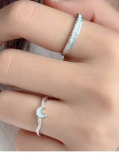 Detailed view of sterling silver couple rings with moon motif and blue enamel inlay