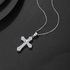 Vintage hip hop cross pendant necklace with sparkling zircons on textured gray background