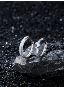 Macro shot of luminous silver couple rings with textured rock finish and blue enamel inlay