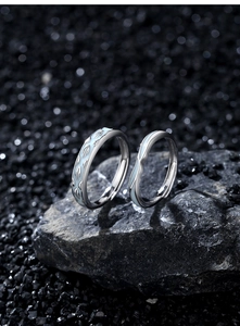 Macro detail of S925 sterling silver couple rings with light blue enamel wing patterns