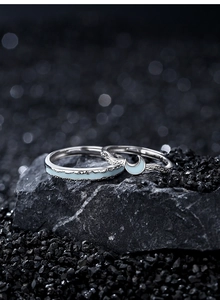 Detail of 925 sterling silver couple rings with luminous moon and star inlay