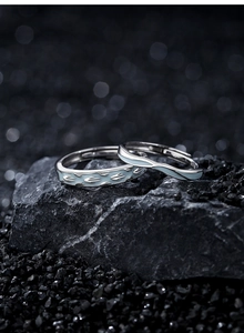 Macro shot of S925 silver couple rings with blue enamel swallow and wave designs