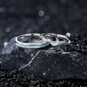 Star and moon themed 925 sterling silver couple rings set displayed on black stones