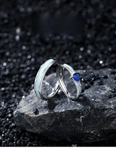 Macro shot of S925 silver couple rings featuring heart blue zircon and wave enamel patterns