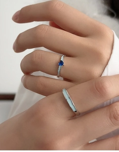 Detail of S925 silver rings with blue heart zircon and light green enamel finish