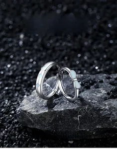 Detailed close-up of S925 sterling silver bowknot rings set on a textured dark stone