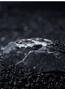 Detailed close-up of S925 silver couple rings with light blue enamel bow and geometric patterns