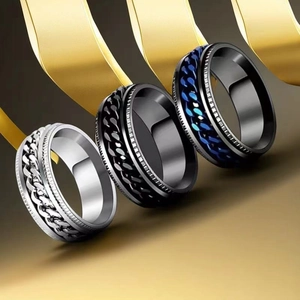 Detailed view of three stainless steel spinner rings with chain link design in black and silver