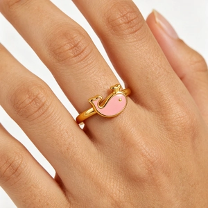 Bague ouverte dorée minimaliste avec un design de baleine rose portée au doigt