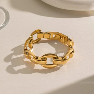 Macro shot of gold stainless steel chunky chain bracelet with fold-over clasp detail