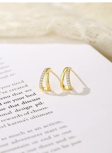 Detailed macro view of gold plated U-shaped hook earrings with pave set white cubic zirconia