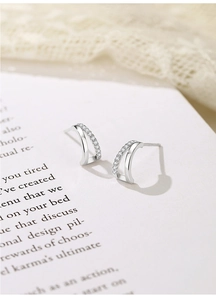 Detail of 925 sterling silver mini zircon stud earrings with double layered curved design