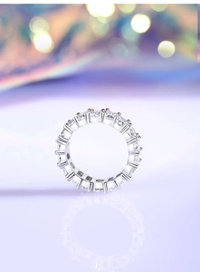Macro detail of S925 silver eternity band with sparkling cubic zirconia on purple surface