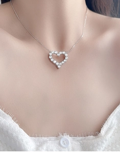 Détail du collier cœur en argent S925 avec pierres moissanite porté par un mannequin