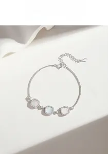 Detailed view of silver bracelet with white shell square charms and crystal pavé
