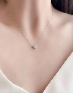 Close-up of minimalist s925 silver V-shaped heart pendant necklace with zircon pavé on neck