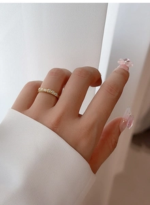 Detalle de anillo minimalista de plata S925 bañada en oro de 18K con cinco piedras de circón