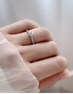 Macro shot of a 925 silver moissanite ring with four-prong setting on a hand