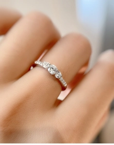 Macro shot of S925 sterling silver three-stone moissanite ring with diamond accents