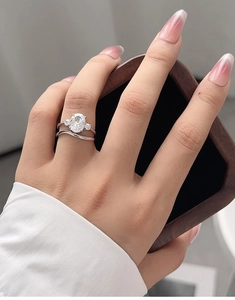 Close-up of S925 silver bridal ring set with oval-cut diamond on a wooden box