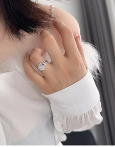 Detail of a pear-cut silver bridal ring set with sparkling zircons on a model finger