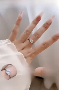 Detailed close-up showing the three-stone moissanite setting and polished silver band