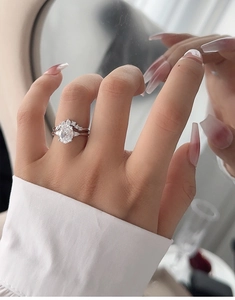 Close-up of elegant S925 silver bridal ring set with oval cut diamond on a hand
