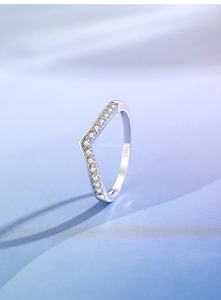 Macro view of V-shaped S925 sterling silver ring with small stones on silk background