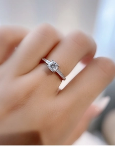 Macro shot of 925 silver moissanite ring with side-set diamonds on the hand