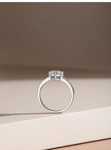 Macro shot of a classic six-prong moissanite ring with side diamonds on a sleek V-shape band