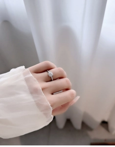 Close-up of S925 sterling silver moissanite ring with pave diamonds on model hand