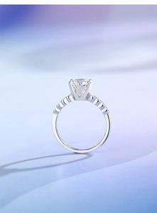 Macro detail of 1-carat moissanite ring with six-prong crown setting on a gradient background