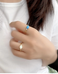 Nahaufnahme von goldenen 925 Silberringen mit ovalen Opalen an der Hand des Models