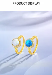 Detail of gold opal rings with white and blue stones on soft silk fabric
