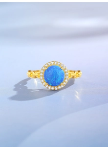 Detail of blue opal ring with white zircon halo and gold chain link band design